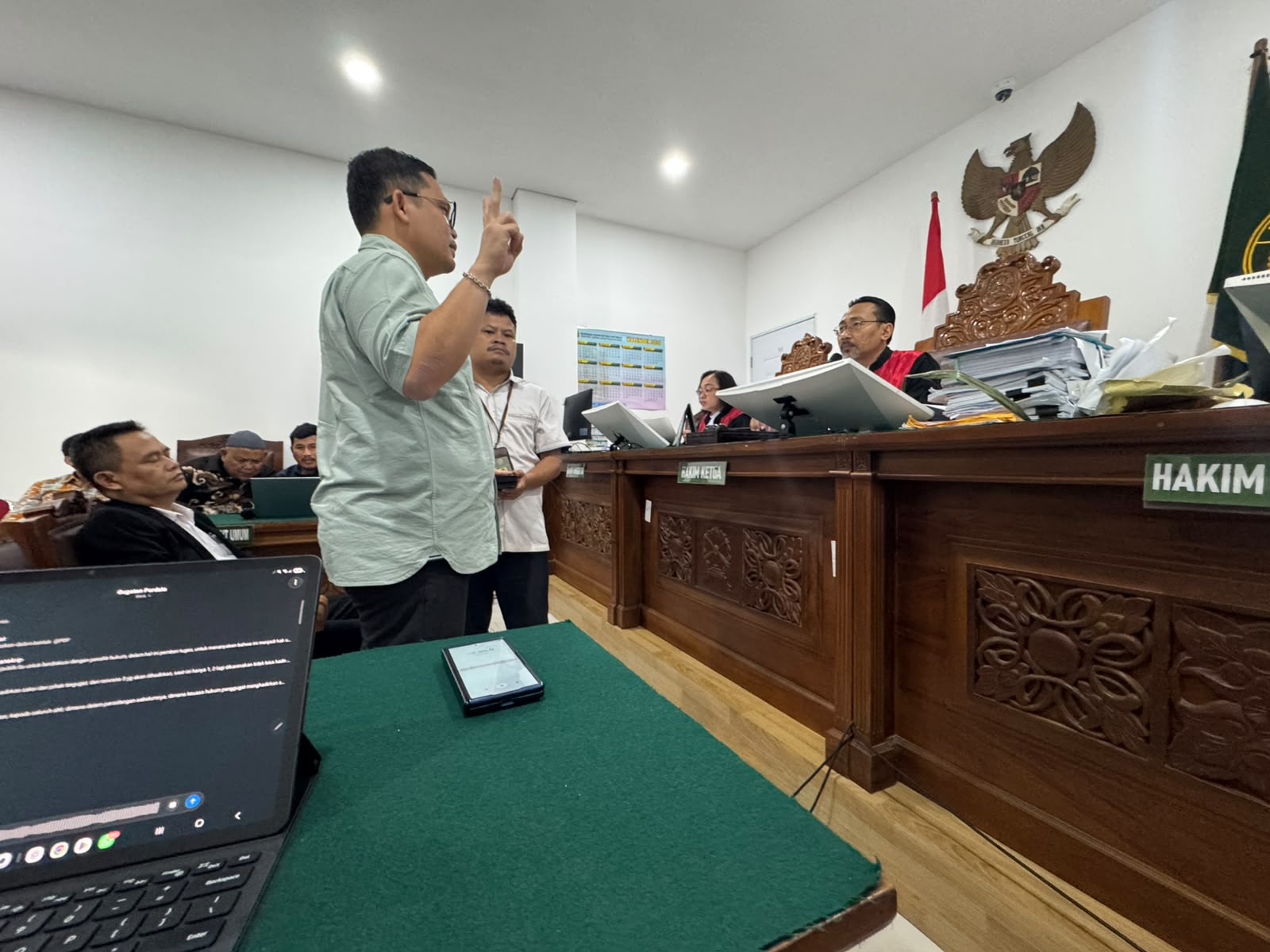 Ryanto Piter berdiri dengan dua jari terangkat, mengucapkan sumpah di hadapan majelis hakim Pengadilan Negeri Jakarta Selatan